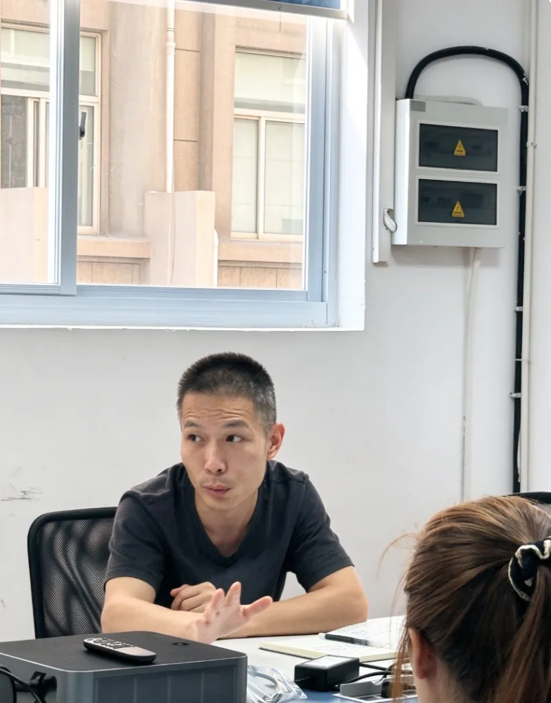 Cross-functional management meeting reviewing production workflow